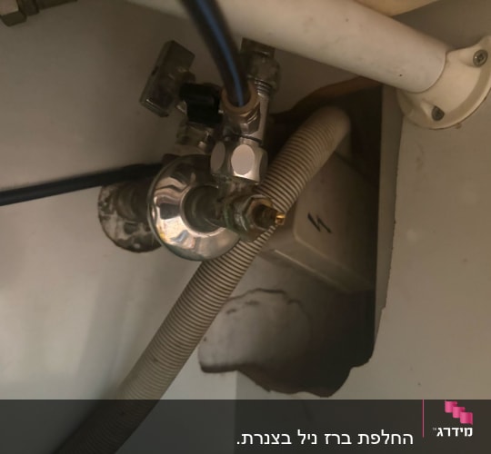 צינור מים מתחת לכיור עם ברזים וחיבורים